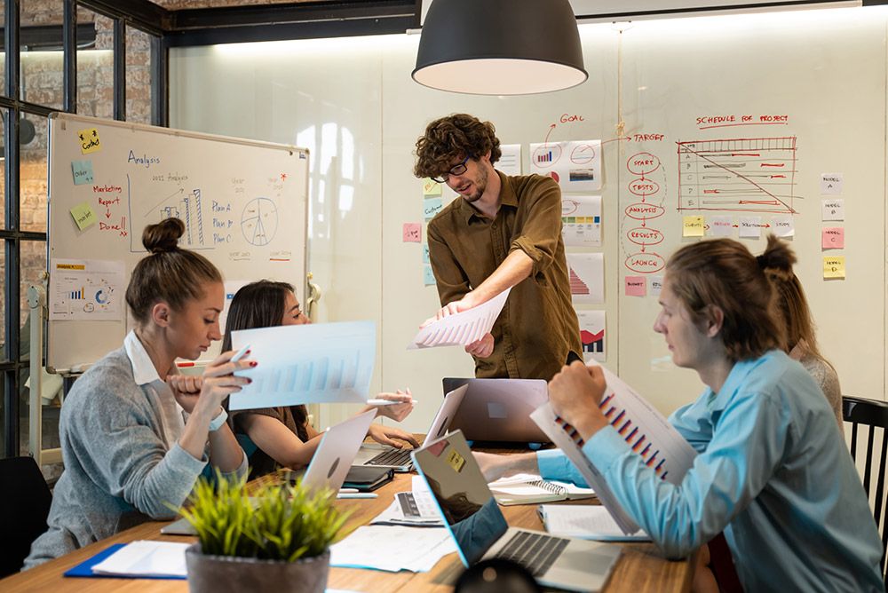 Product team reviewing feature documents and charts in a conference room.